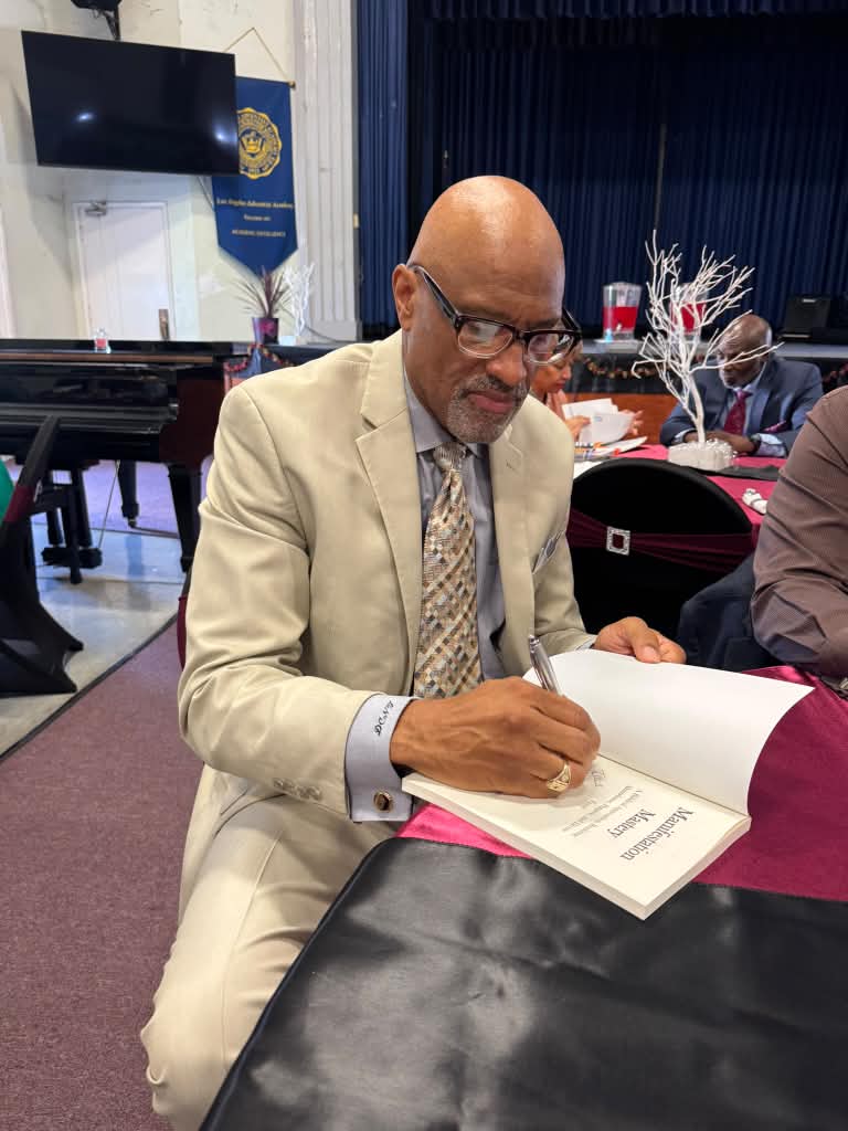 Dr. Nos signing a copy of Manifestation Mastery